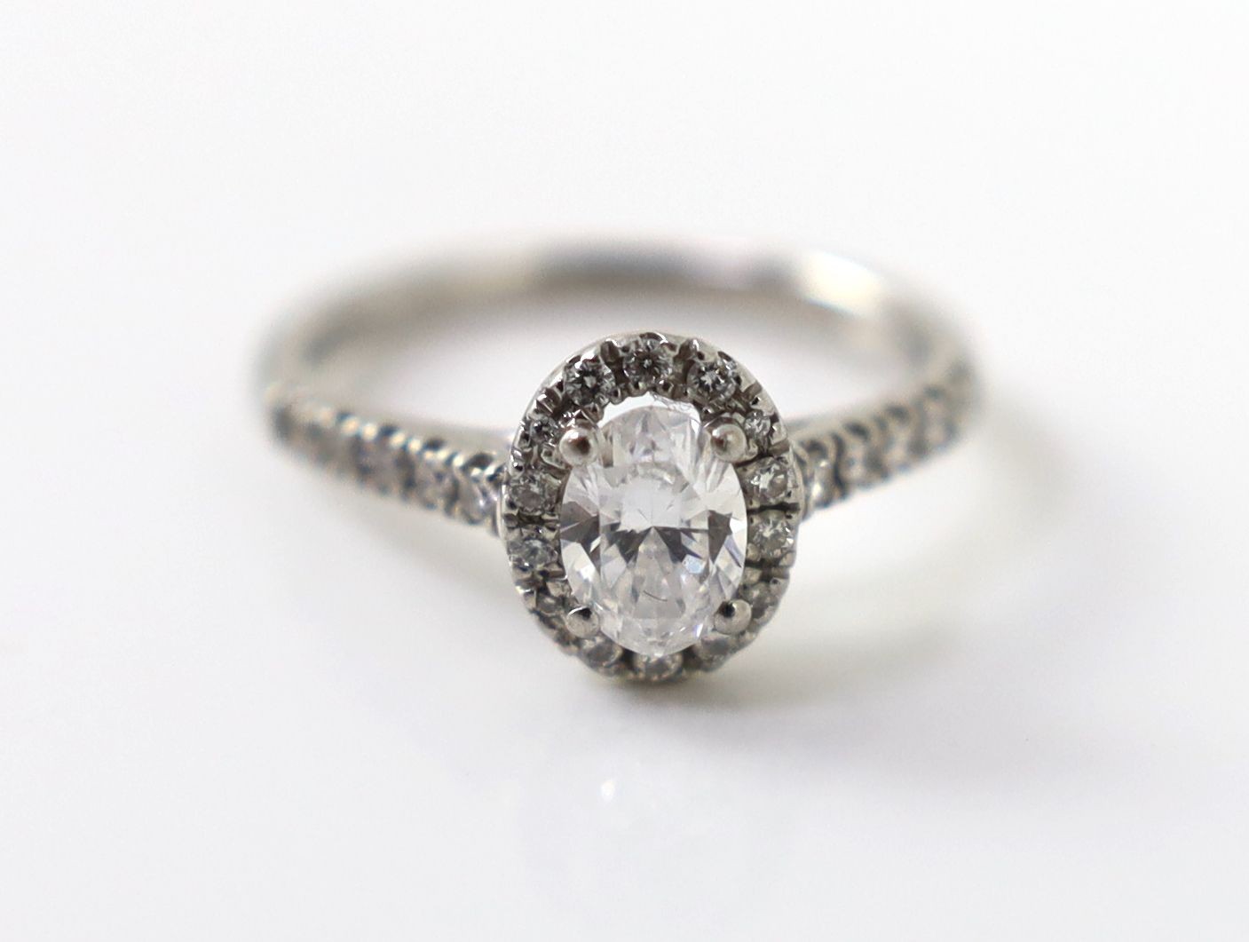 A modern platinum and single stone oval cut diamond set ring, with diamond setting and diamond set shoulders, with accompanying GIA report dated 13/8/2019, stating that the oval brilliant cut diamond to weigh 0.70ct with